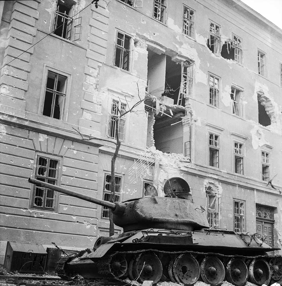 Panzerwagen vor einem zerbombten Haus in Ungarn